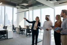 A commercial real estate agent touring an open-plan fitted commercial office space in Dubai with corporate clients overlooking the Downtown skyline.